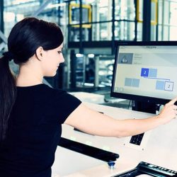 Employee at the Pick-it-Easy work station operating an easyUse user interface on a touch screen. The easyUse interfaces increase usability and the user experience in the warehouse for warehouse workers