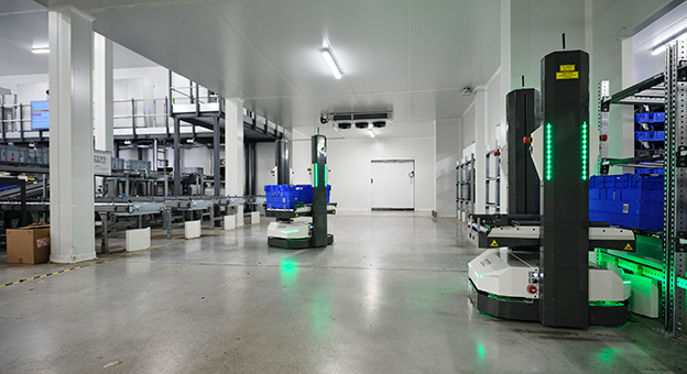 Open Shuttles übernehmen den Transport und die Sortierung von fertiggestellten Aufträgen in einem Micro Fulfillment Center. Die autonomen mobilen Roboter, die Open Shuttles, transportieren Behälter vom Wareneingang zum automatischen Lagersystem. Dabei navigieren sie ohne optische und physische Hilfsmittel durch das Lager.