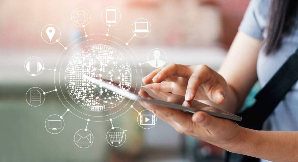 Datos inteligentes en todos los terminales; éxito en logística y producción; interconexión, software La imagen muestra un terminal móvil que maneja una mujer. La mujer sostiene la tablet en su mano izquierda y la maneja con su mano derecha a través de la pantalla táctil. En la tablet encontramos elementos gráficos que representan un mundo interconectado por datos. Los caracteres e iconos simbolizan los servicios que cubre Internet, como las compras en línea, correo electrónico, lugares, etc.