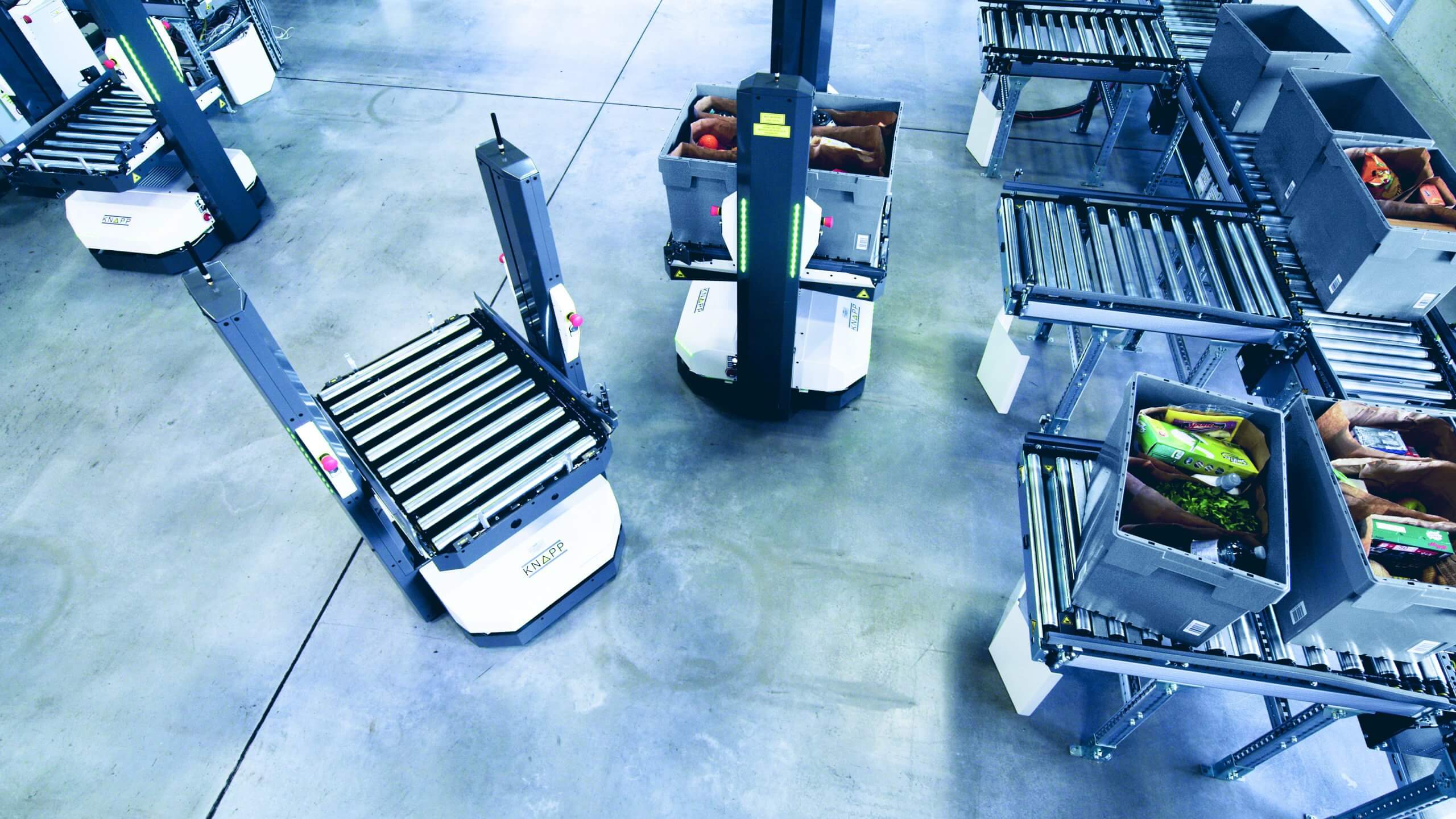 KNAPP_Open_Shuttle_MFC_Lebensmittel_E-Commerce Les robots mobiles autonomes se chargent des commandes dont le prélèvement est terminé directement depuis le système de convoyage qui est connecté aux postes de travail.