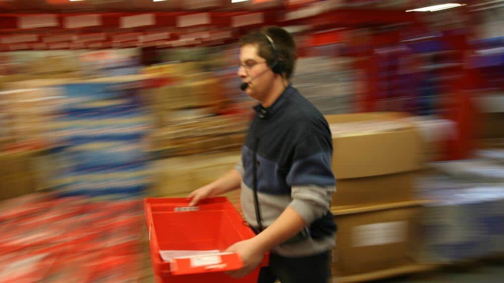 Employee with headset for Voice Picking for paperless picking of an order.