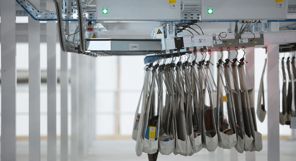 The image shows the intelligent pocket sorter system at customer REI. The pocket sorter is a sorting and sequencing system with adapters for sorter pockets or hangers. The pocket sorter is a product from Dürkopp Fördertechnik, a member of the KNAPP Group