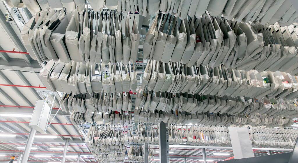 Taschensorter Netretail Prag Ecom Fulfillment Dürkopp Fördertechnik Ansicht von unten auf ein Dürkopp Fördertechnik Taschensorter-System zum Sortieren von Hänge- und Liegewaren beim tschechischen Onlinehändler mall.cz. Viele Sortertaschen sind von unten zu sehen. Die Sortertaschen werden mit mithilfe eines Taschensorter-Systems (Pocket Sorter) befördert. In jeder Sortertasche wird ein Stück Ware transportiert. Jede Sortertasche im Taschensorter System ist mit einem RFID-Chip ausgestattet. So kann jede Sortertasche im Pocket Sorter einfach aufgefunden werden.