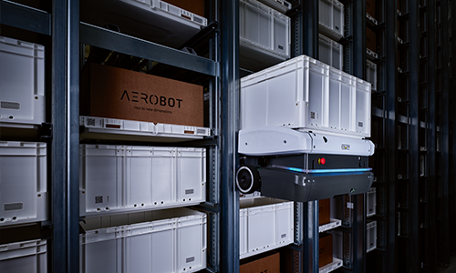 A robotic warehouse featuring a robot retrieving a white storage container from the rack marked with “AEROBOT”.