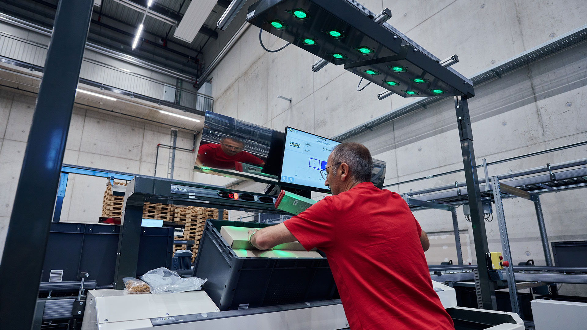 Victorinox employee stands in front of a goods-to-person workstation and does value-added services.