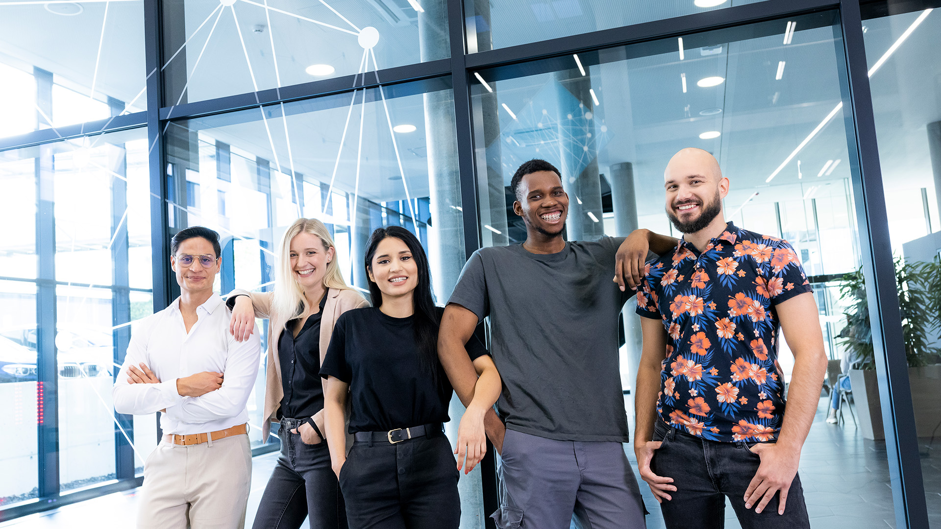 Five employees of various nationalities stand close together and smile