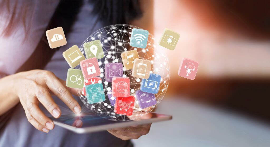 Datos inteligentes en todos los terminales; éxito en logística y producción; interconexión, software, comercio electrónico, comercio minorista de comestibles, Food Retail, omnicanal La imagen muestra un terminal móvil que maneja una mujer. La mujer sostiene la tablet en su mano izquierda y la maneja con su mano derecha a través de la pantalla táctil. En la tablet encontramos diferentes elementos gráficos que representan un mundo interconectado por datos. Los caracteres e iconos simbolizan los servicios que cubre Internet, como las compras en línea, correo electrónico, lugares, etc.