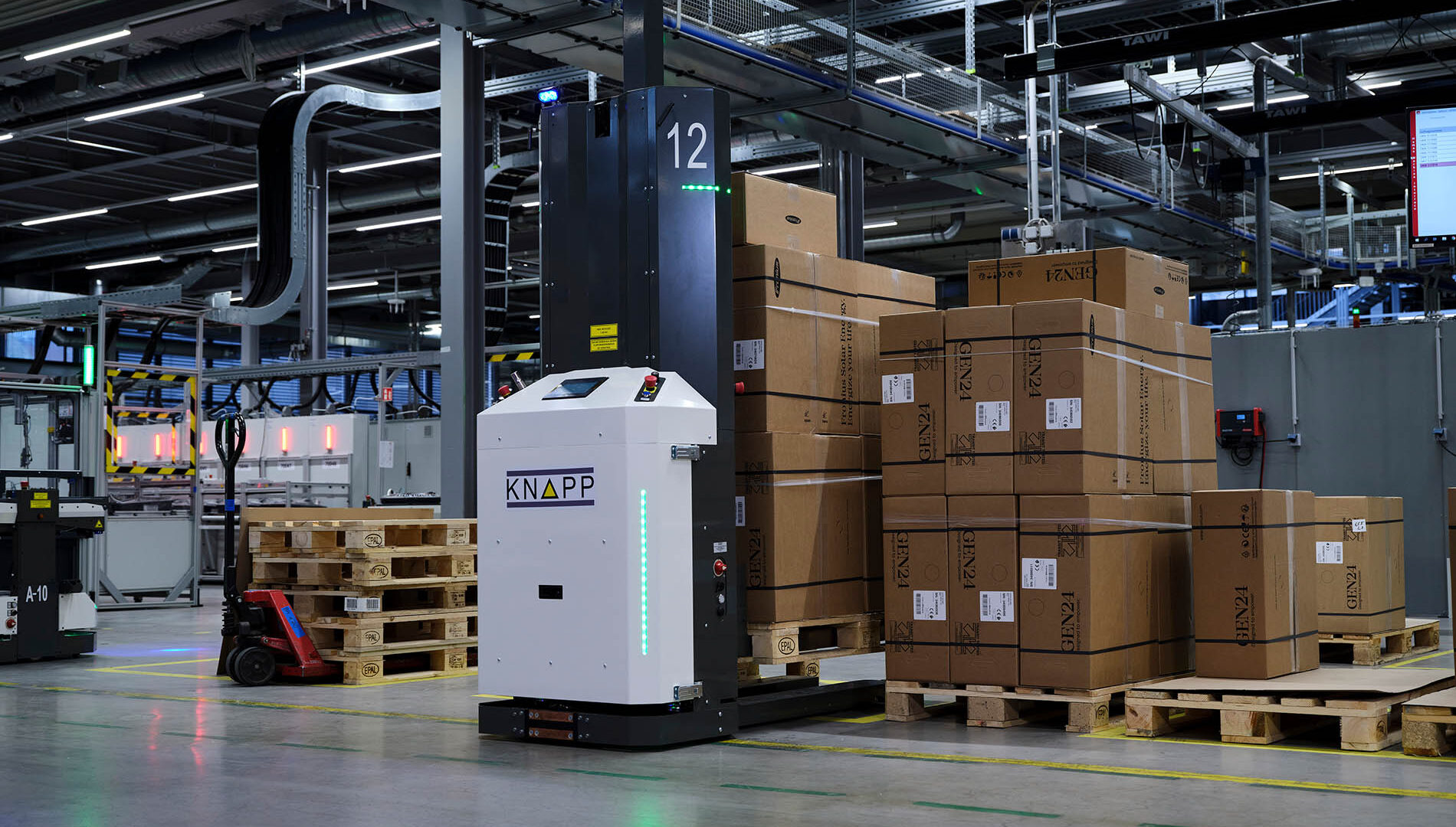 Un entrepôt moderne avec des cartons empilés sur des palettes, un robot autonome KNAPP et des équipements industriels sous des lumières vives. Le décor est organisé et high-tech.