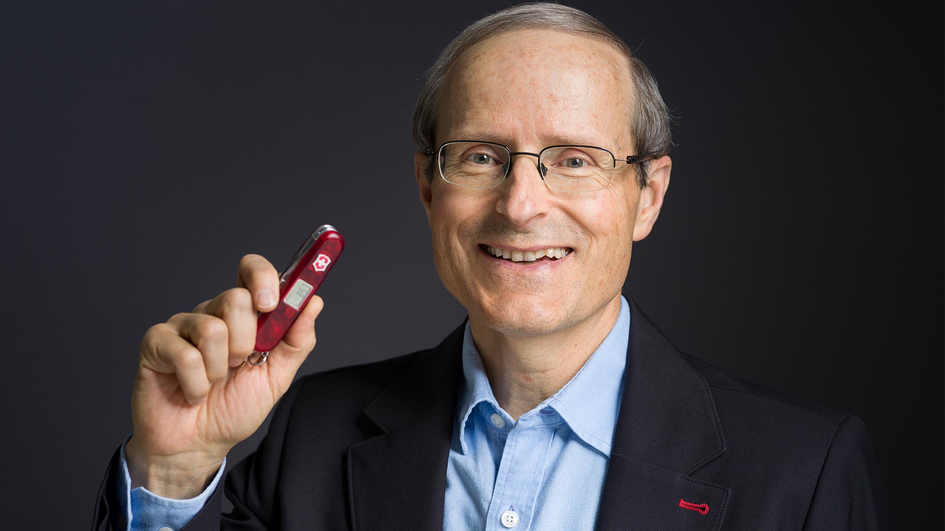 Image de Carl Elsener, CEO de Victorinox, avec un couton suisse à la main.