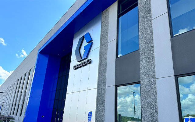 Bâtiment moderne avec de grandes fenêtres, façade bleue et blanche, logo GRACO à l'entrée-le partenariat qui renforce les chaînes d'approvisionnement.