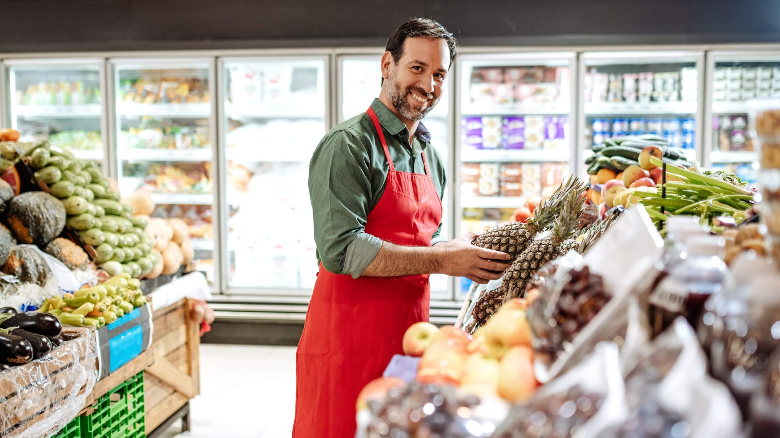 Mitarbeiter räumt Artikel im Supermarkt ein