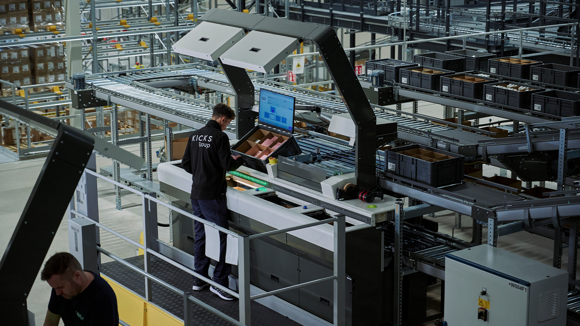 Kicks_warehouse Zwei Mitarbeiter arbeiten in einer modernen Lagerhalle der Firma Kicks
