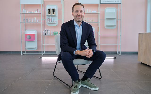 Kicks_warehouse_Coo David Heeroma, EVP COO der Matas Group, sitzend auf einem Stuhl, dahinter eine Auswahl an Produkten von KICKS.