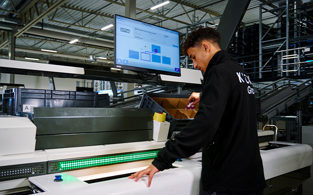 Kicks_warehouse_kommissionierung Ein Mitarbeiter kommissioniert Artikel an einer Ware-zur-Person Pick-it-Easy Evo Arbeitsstation