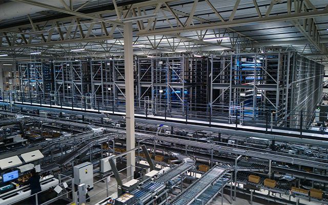 Kicks_warehouse_lagerung Automatisiertes Lager, mit Ausschnitt des Evo Shuttle Kleinteilelagers, Fördertechnik und Ware-zur-Person Pick-it-Easy Arbeitsstationen.