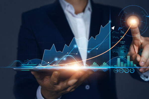 Kisoft-wcs-hero Eine Person im Anzug hält ein Tablet in der Hand, auf dem leuchtende virtuelle Diagramme zu sehen sind, die das Finanzwachstum und die von KiSoft WCS gesteuerte Datenanalyse verdeutlichen.