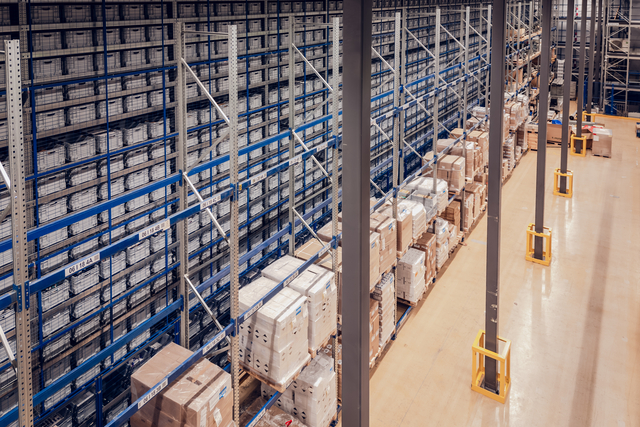 KNAPP-Apotek 1 Oslo 028-RGB_Small Reihen von hohen Industrieregalen, gefüllt mit Kisten und Paletten, zeigen, wie Victorinox auf eine zentrale Distribution in einem großen, übersichtlichen Lager setzt.