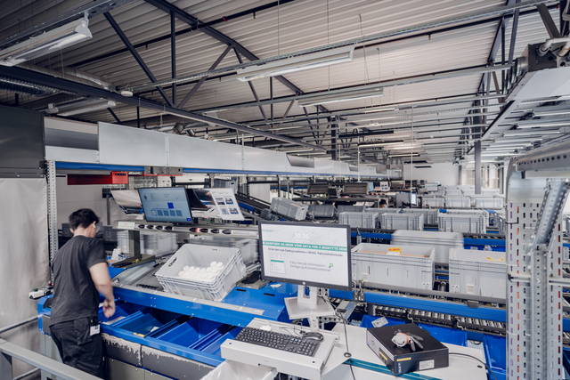 KNAPP-Apotek 1 Oslo 127-RGB_Small Ein Mitarbeiter bedient die Sortieranlage in einem modernen Lager, in dem Victorinox auf eine zentrale Distribution für eine effiziente Logistik und rationelle Abläufe setzt.