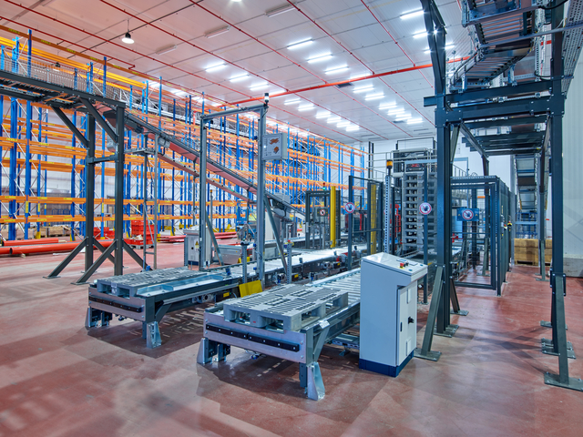 Automatisierte Maschinen und Förderanlagen sorgen für maximale Frische durch maßgeschneiderte Automatisierung in einem großzügigen, modernen Lager mit heller Beleuchtung.