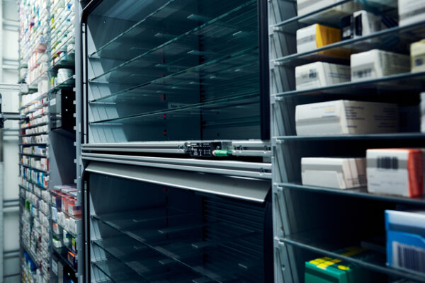 Mit Medikamentenschachteln gefüllte Regale in einem Apothekenlager mit einem automatischen Ausgabesystem - ähnlich wie Victorinox auf zentrale Distribution setzt.