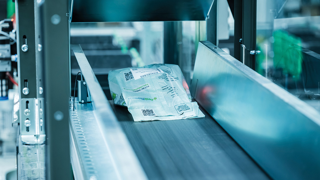 Los medicamentos embalados en un polybag se mueven mediante una banda transportadora.