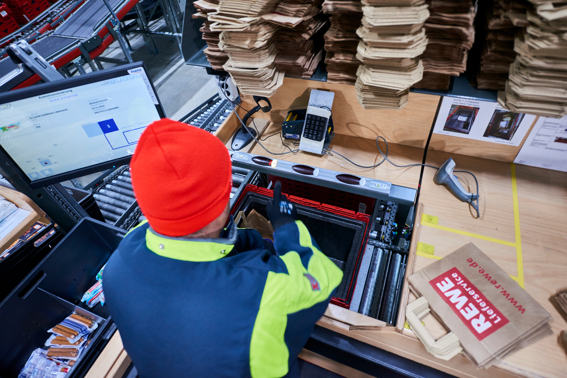 Die Artikel werden in Papiertüten gepicked. Die Software leitet die Mitarbeiter durch den Prozess.