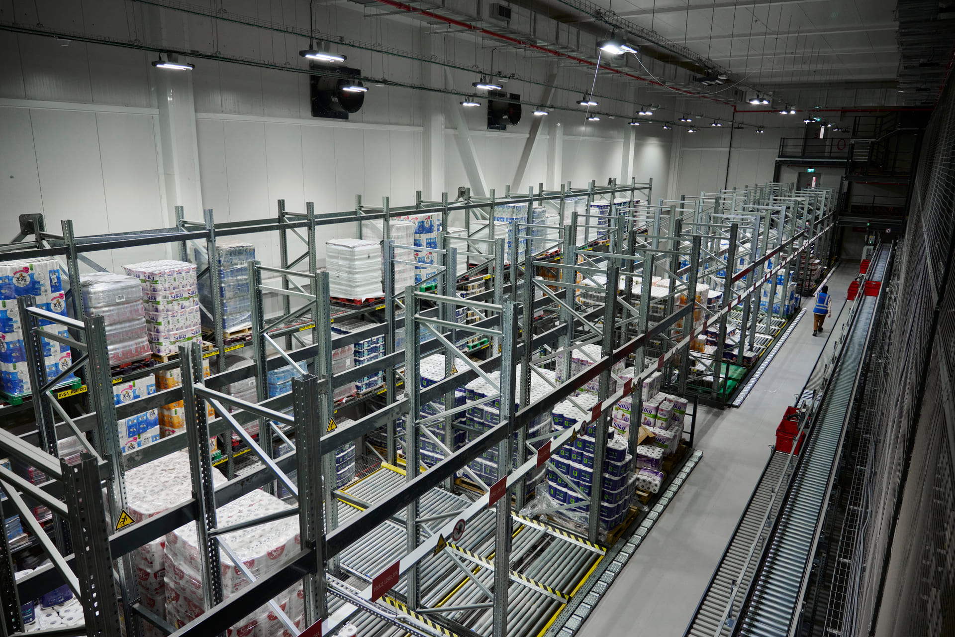 Automatisiertes Lager mit Fördertechnik und hohen Regalen für flexible Warenlogistik