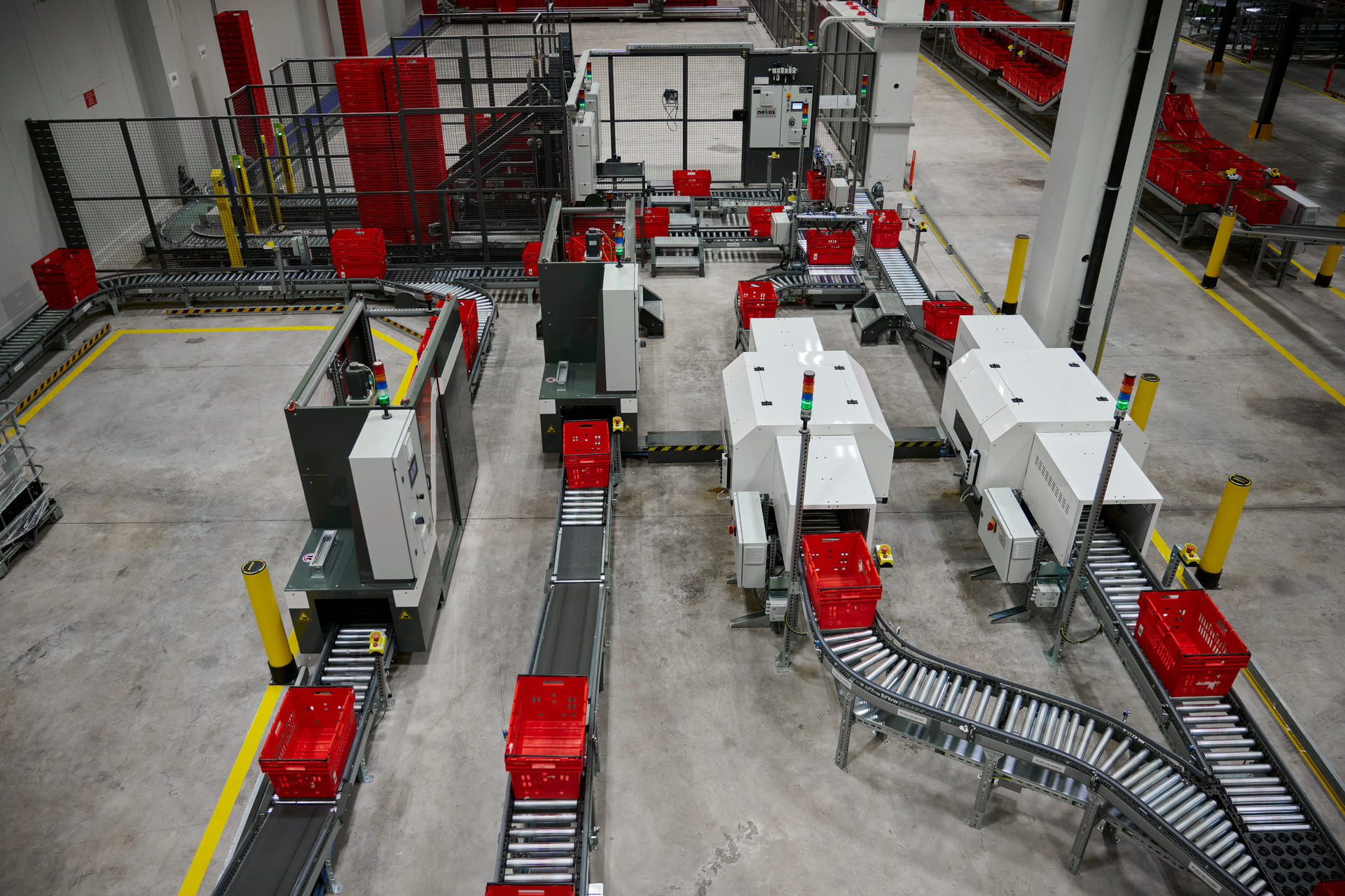 Automatisiertes Logistikzentrum mit Fördertechnik und roten Transportbehälter