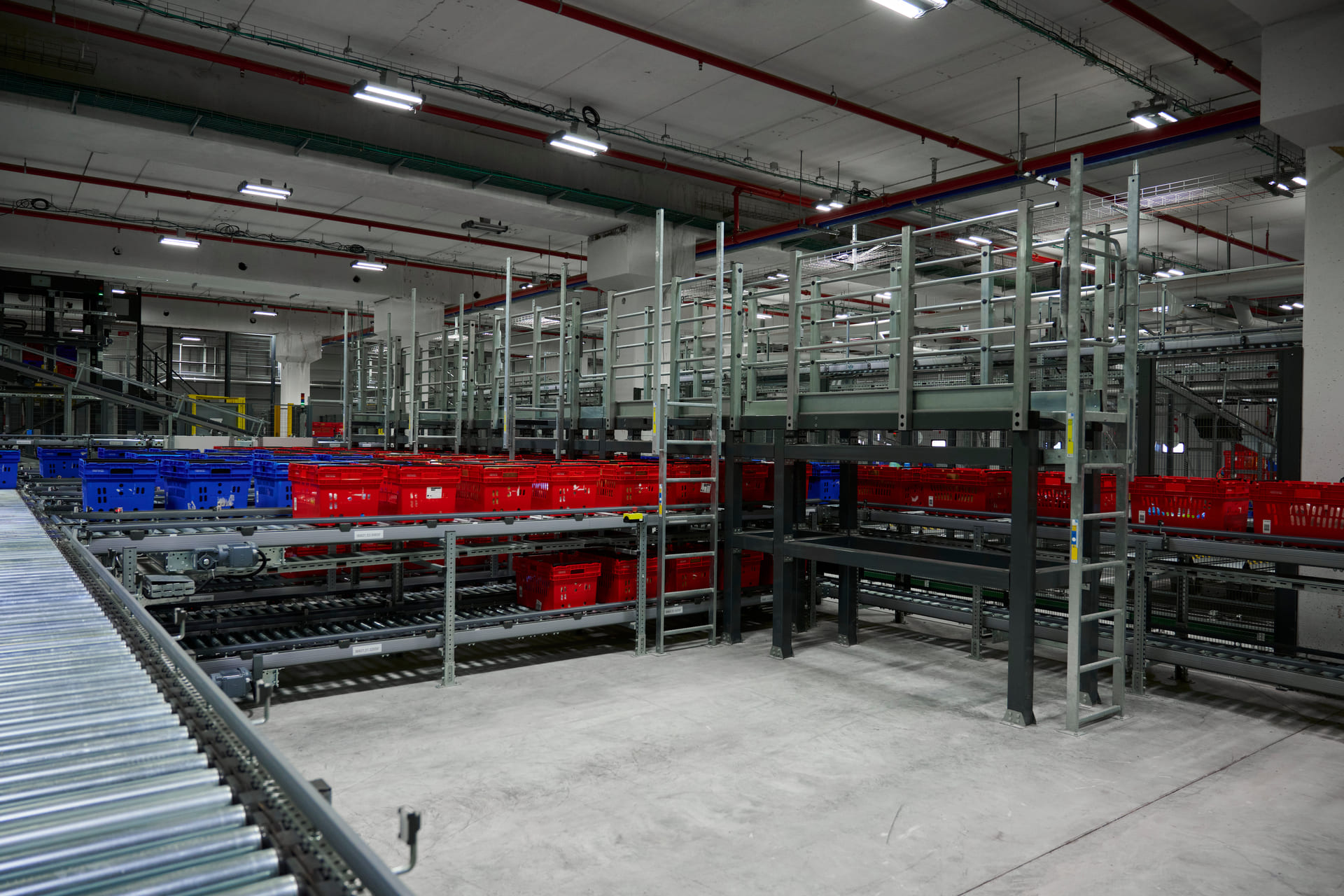 Automatisiertes Lager mit Fördertechnik und farblich sortierten Transportbehältern