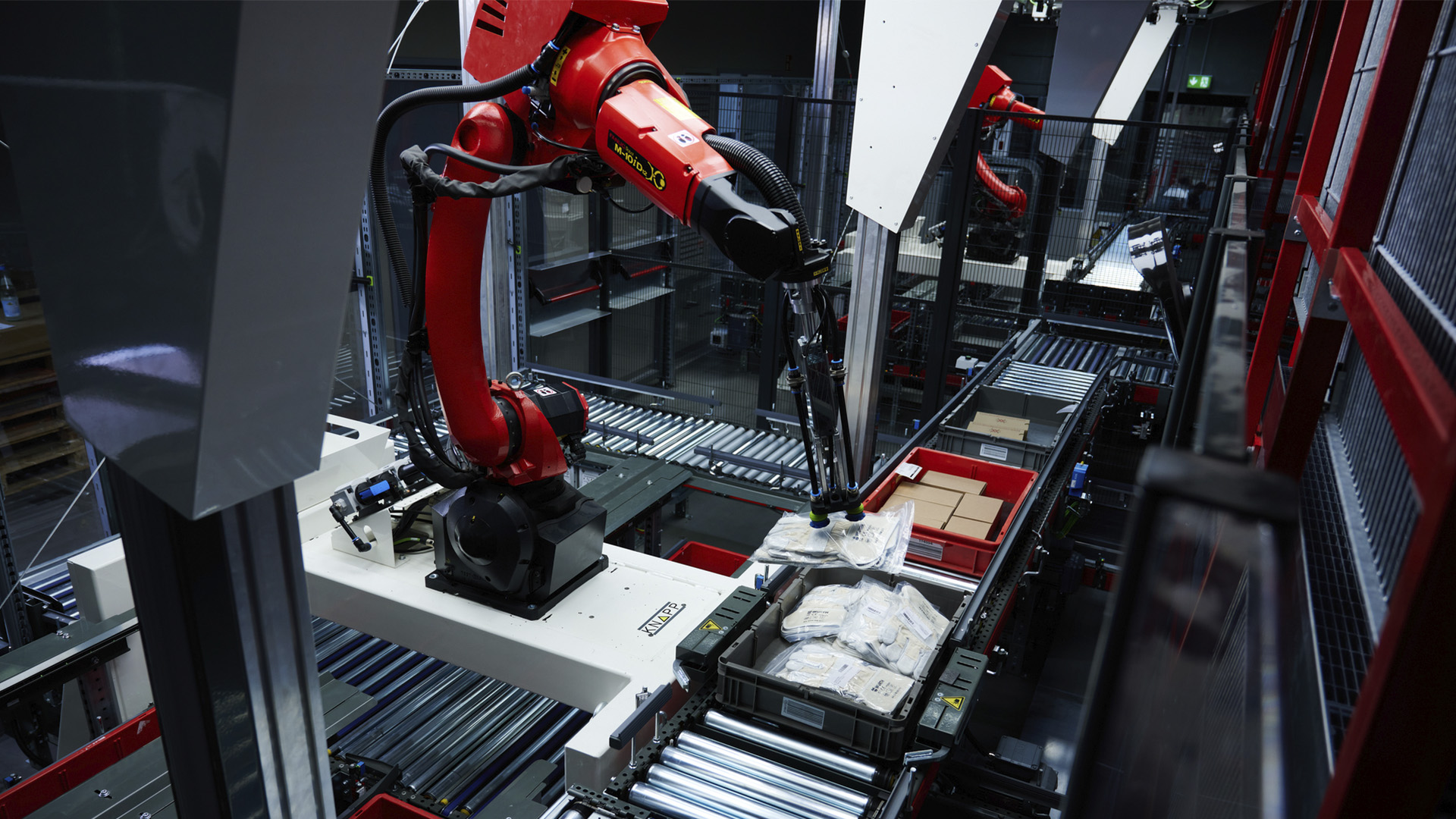 Automatisierung in der Intralogistik durch Pick-it-Easy Robot, der Teile in einer Kiste auf einer Fördertechnik aufhebt.