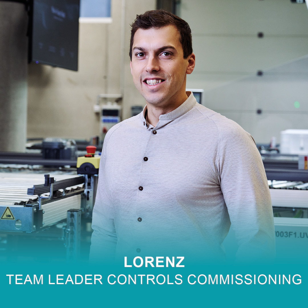 Teamleiter Controls Commissioning Lorenz steht in einem Lager und lächelt in die Kamera