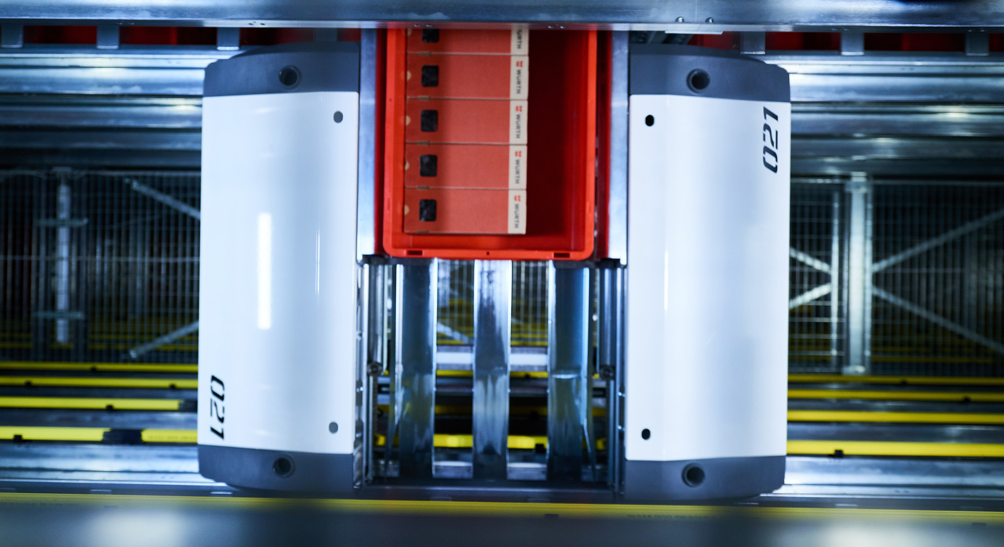Conteneurs réutilisables chez Würth Autriche dans l’OSR Shuttle Evo de KNAPP. Un conteneur en plastique rouge qui est utilisé comme conteneur réutilisable durable dans la livraison aux magasins et qui est ici entré en stock via le système de navettes de KNAPP.
