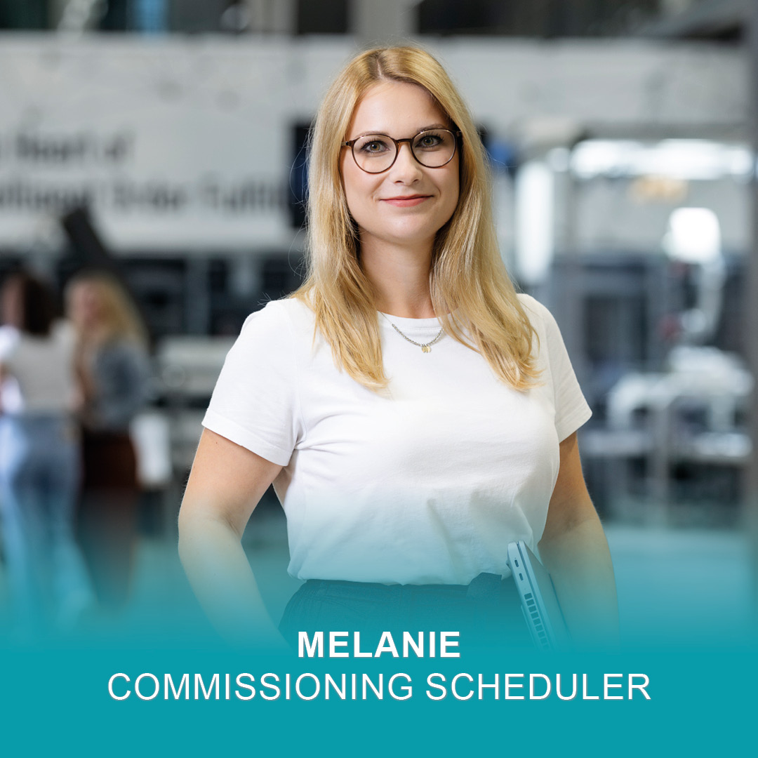 Commissioning Scheduler Melanie hält ihren Laptop unterm Arm und lächelt in die Kamera
