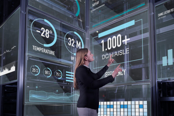 Mit Software ans Steuer Femme utilisant plusieurs écrans numériques transparents sur lesquels s’affichent des données de température et d’efficacité