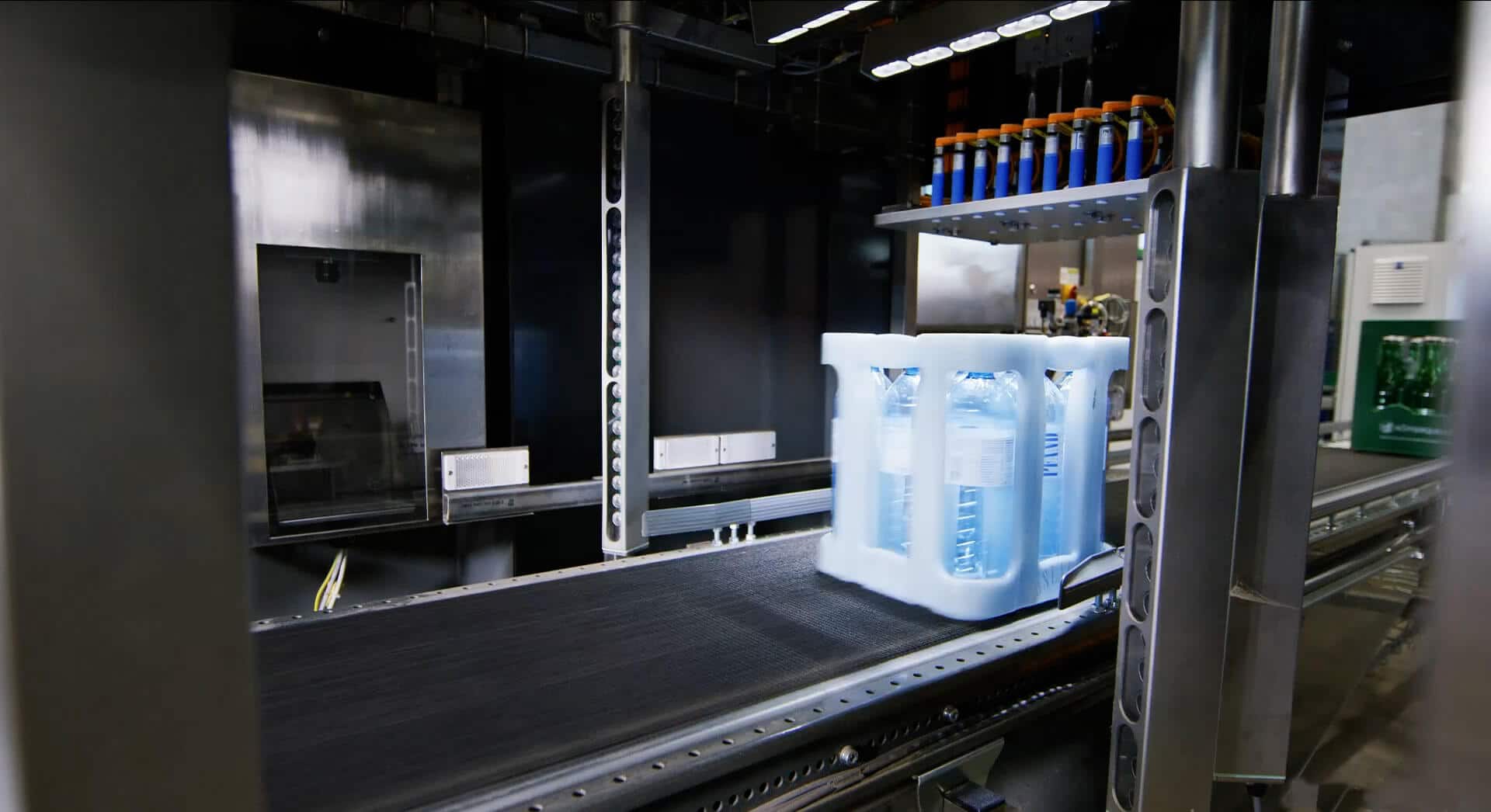 Inside view of a deposit value recognition machine. A “Vöslauer” water crate passes through the machine. The image shows a picture being taken of this crate.