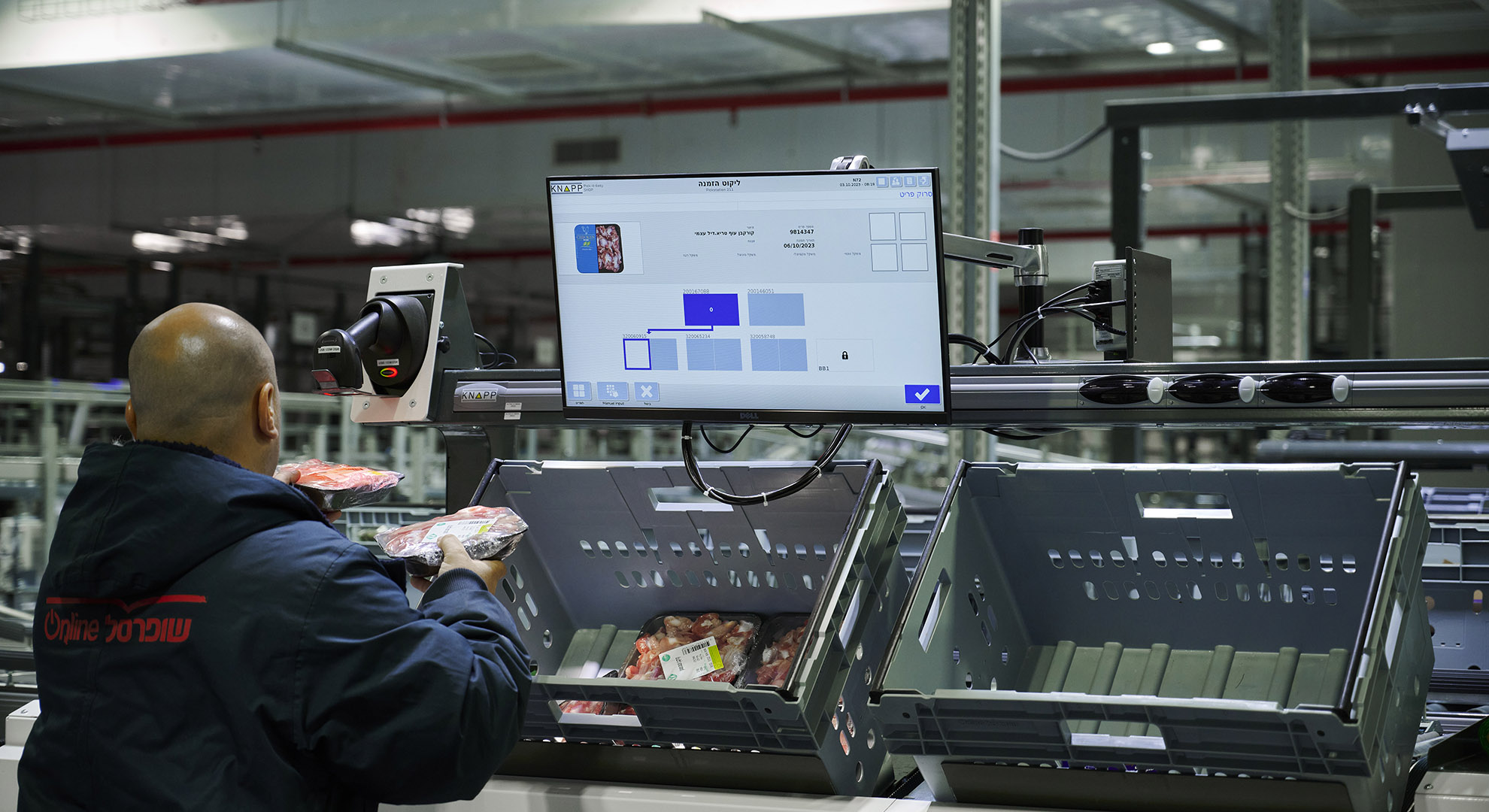 An employee is picking refrigerated and frozen products at an ergonomic work station.