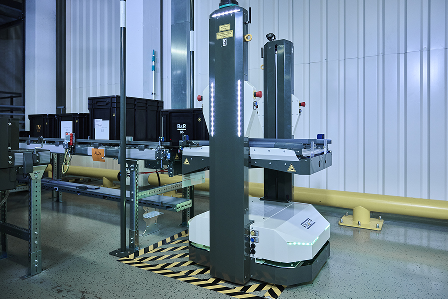 Production logistics by AMR at B&R An autonomous mobile robot by KNAPP picks up containers from the shuttle system at a conveyor.