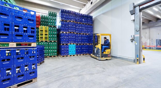 Vista frontal de numerosas cajas de bebidas clasificadas apiladas en palets. Con ayuda de nuestra solución de envases vacíos, al final del proceso los contenedores clasificados están listos para ser recogidos por los fabricantes y productores.