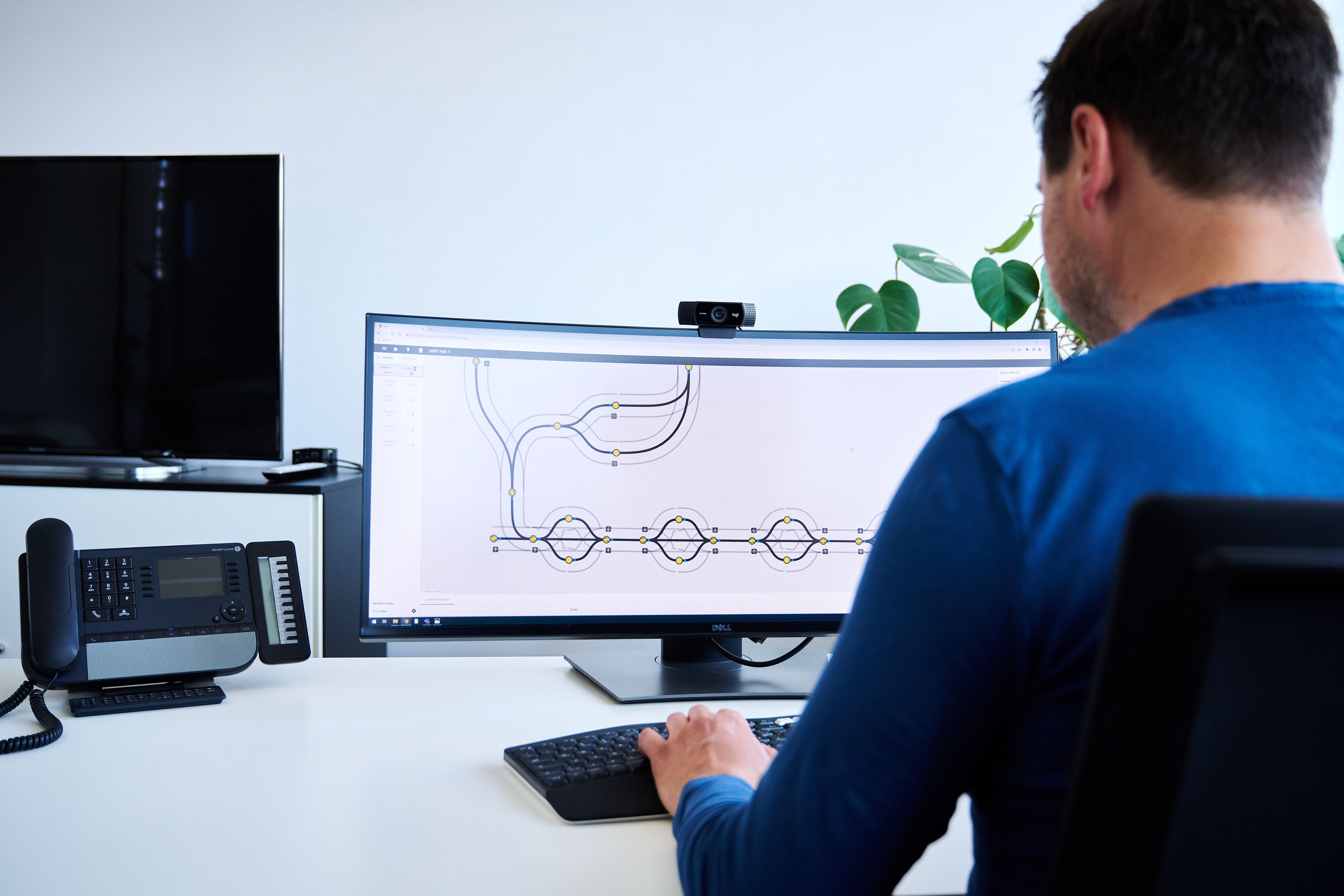 Saving resources using a digital twin A man views two AMR paths on a monitor