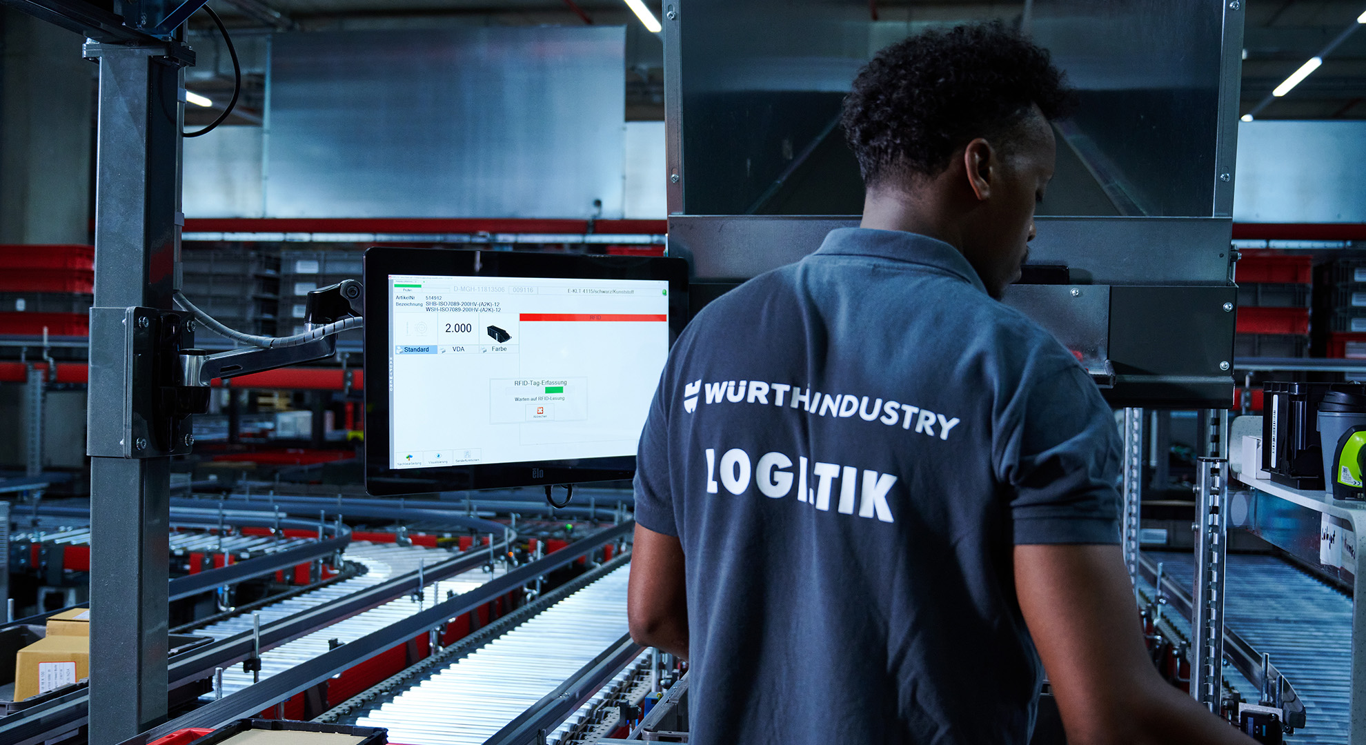 Würth_Pick-it-easy-Arbeitsplatz Ein Mitarbeiter steht vor dem ergonomischen Pick-it-Easy-Arbeitsplatz und kommissioniert die Aufträge im Ware-zur-Person-Prinzip.