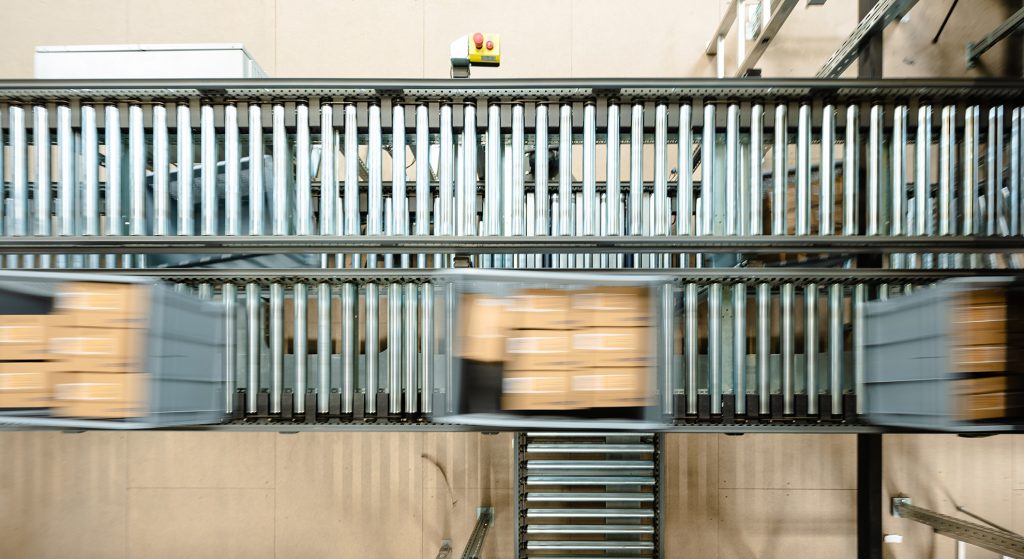 De nouveaux concepts logistiques pour des traitements de commande plus rapides Les colis sont transportés dans l’entrepôt à l’aide d’un système de convoyage automatisé