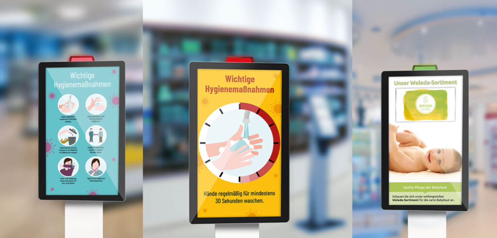 Three digital pharmacy screens display hygiene tips, handwashing instructions, and a product advertisement in German.